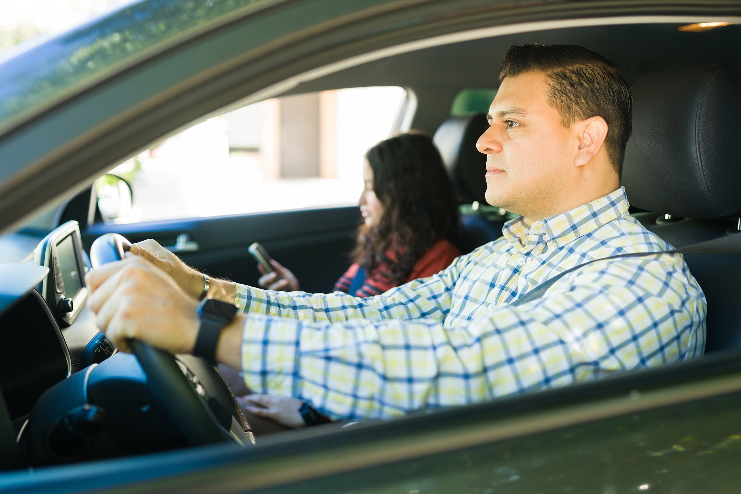 Man focused on driving with daughter sitting in passenger seat