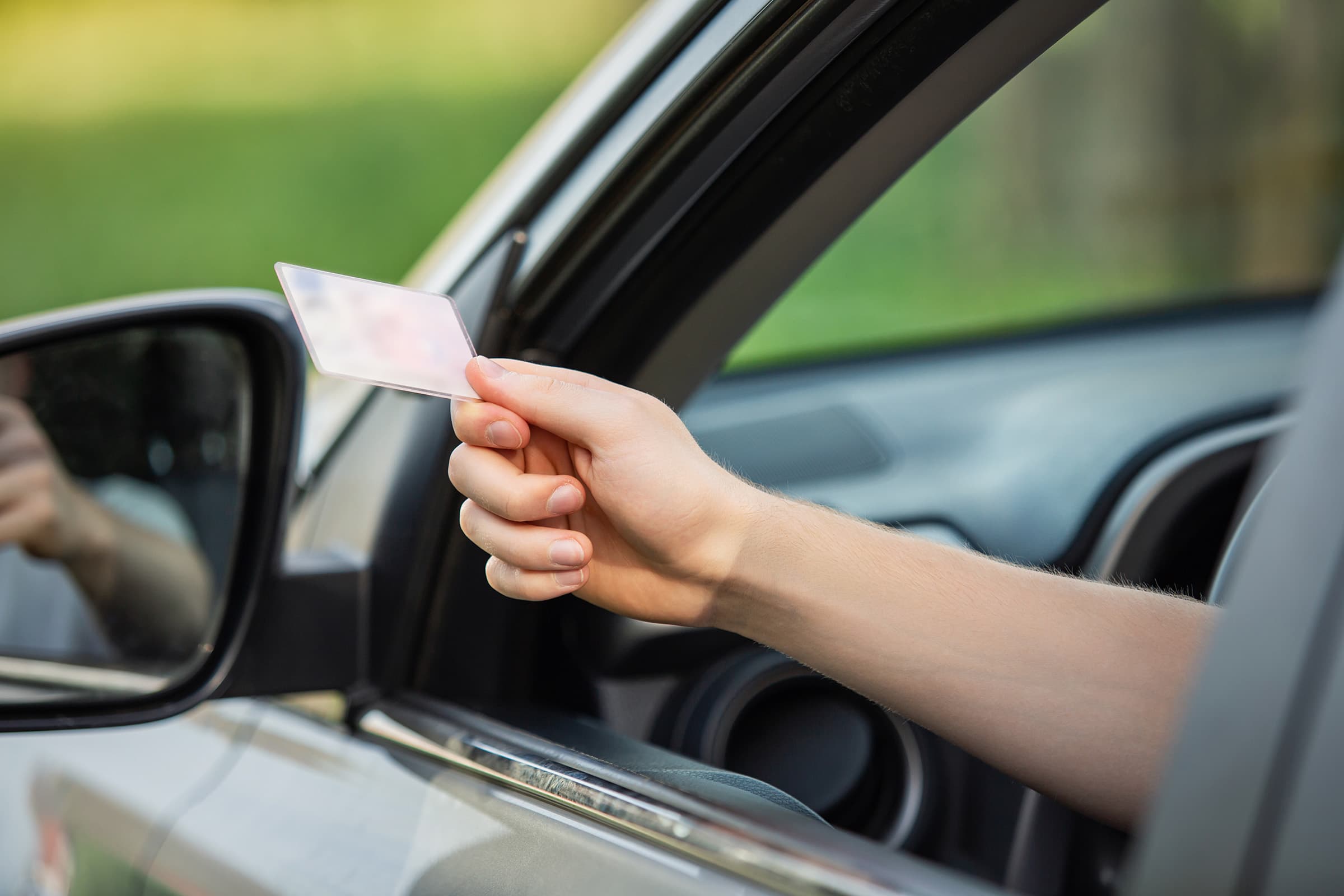 Person showing driver's license out car window