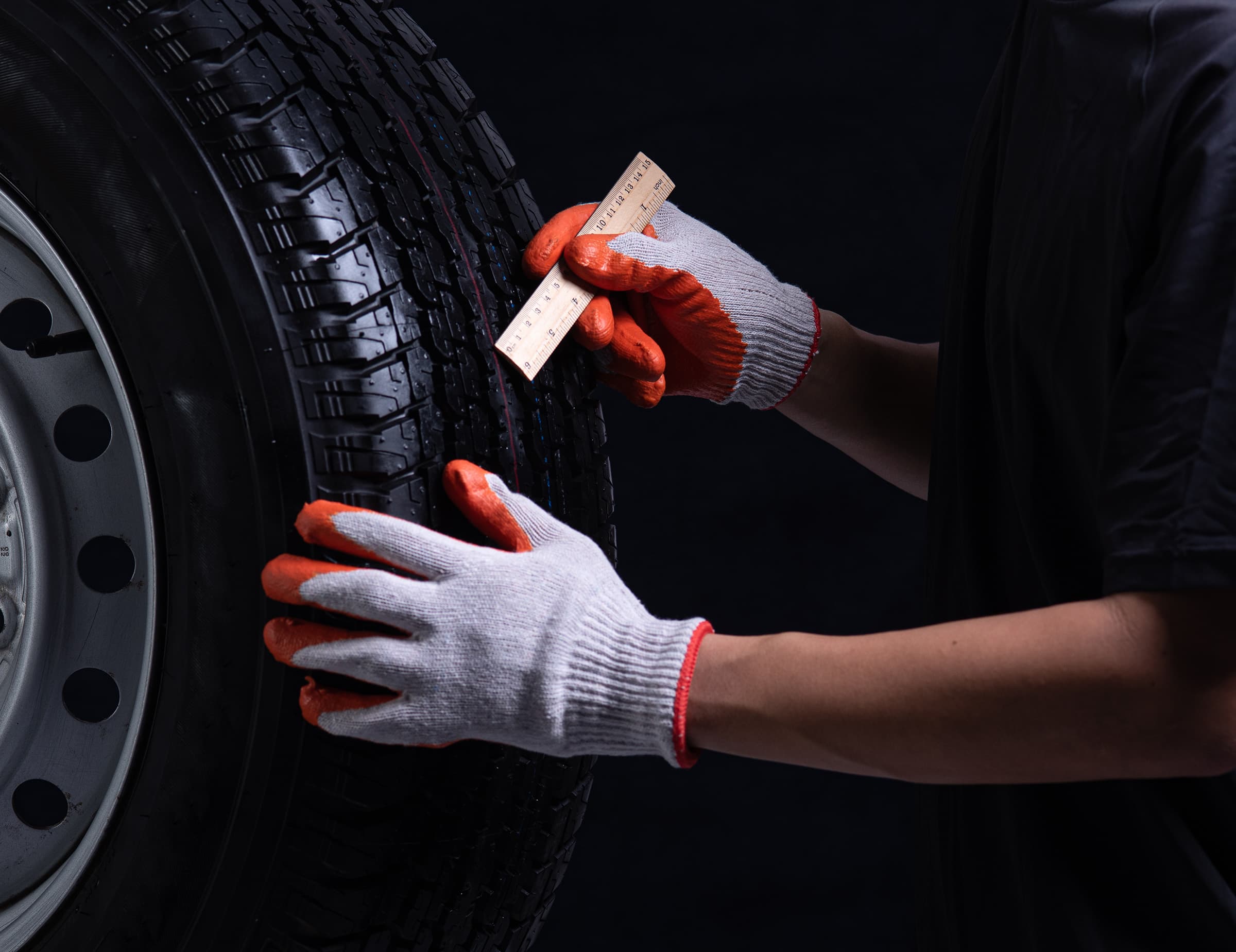 Technician checking tread on tires