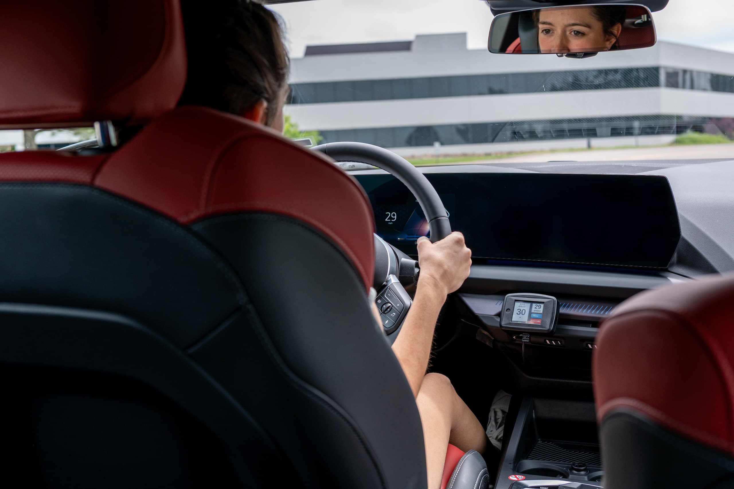 Teen driving safely under speed limit with Intelligent Speed Assistance device displaying speed