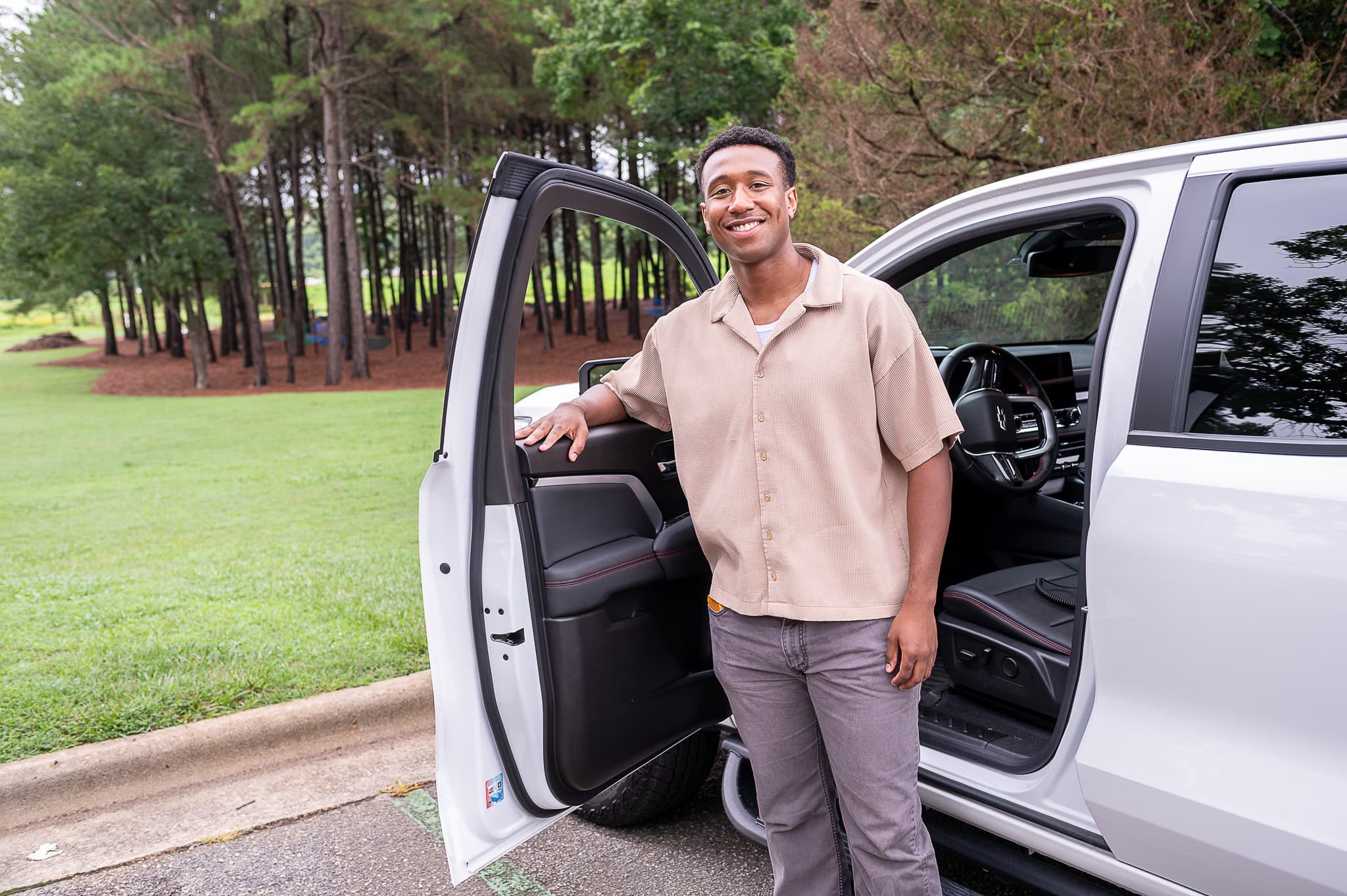 Man standing in front of opened car door smiling