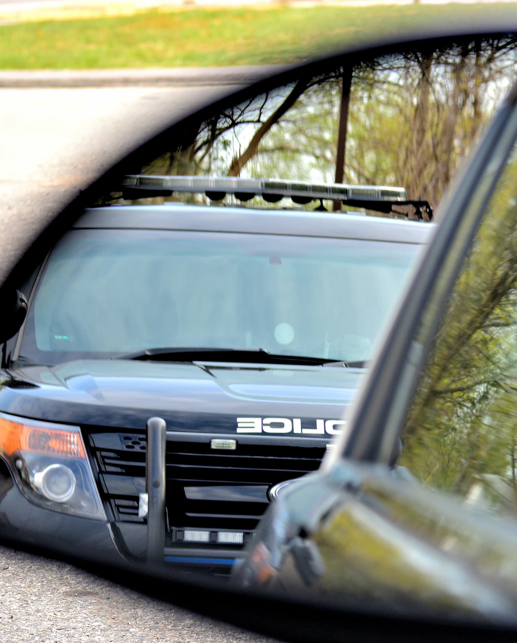 View of police car in side view mirror